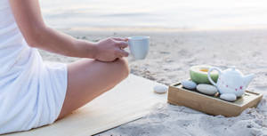 Woman enjoying a cup of tea on the beach
