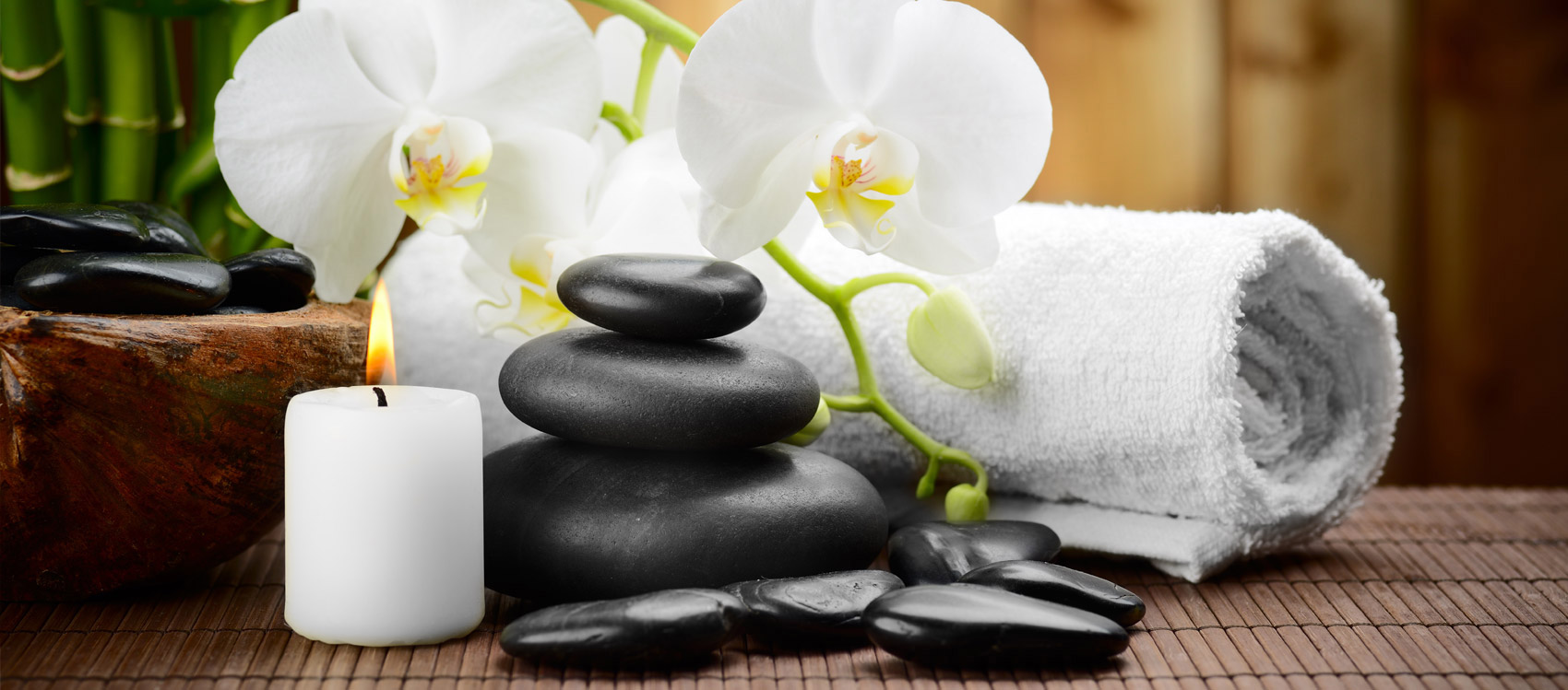 Flowers, towels and a balanced stack of massaging stones